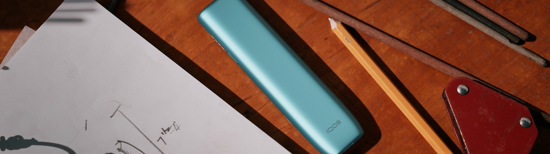  A person holding an IQOS ILUMA i prime Color Midnight Black